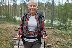 Retired woman walking in forest adventuring