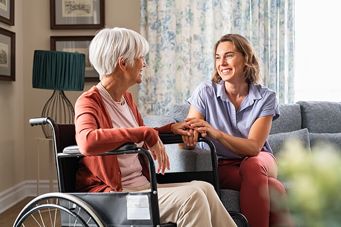 a woman in a wheelchair talking to a woman on a sofa