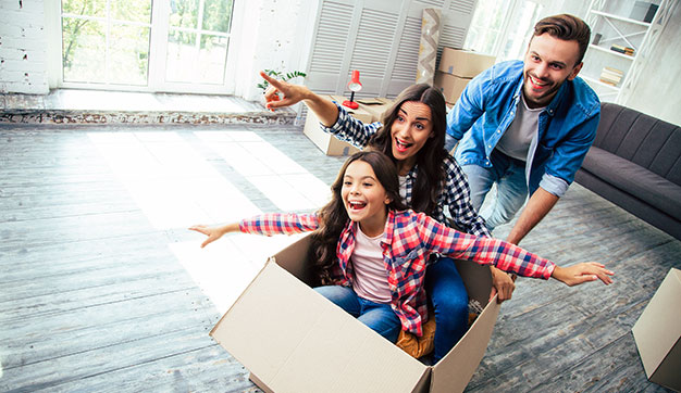 Expat Family laughing and playing in cardboard box as they look to the future.