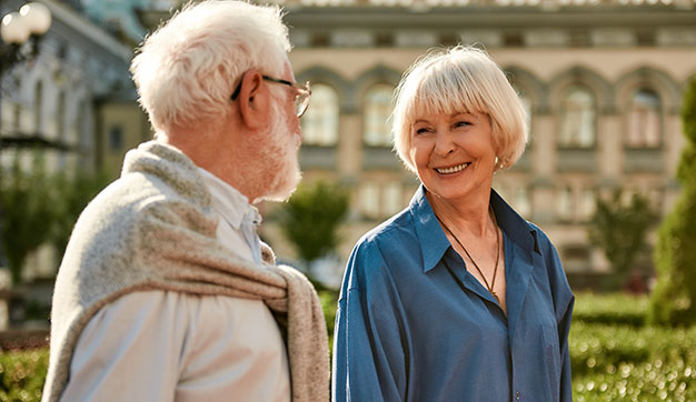 Retired expat couple walking and staring lovingly into each other’s eyes