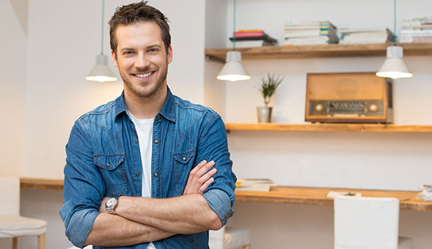Young confident expat man arms folded smiling at camera