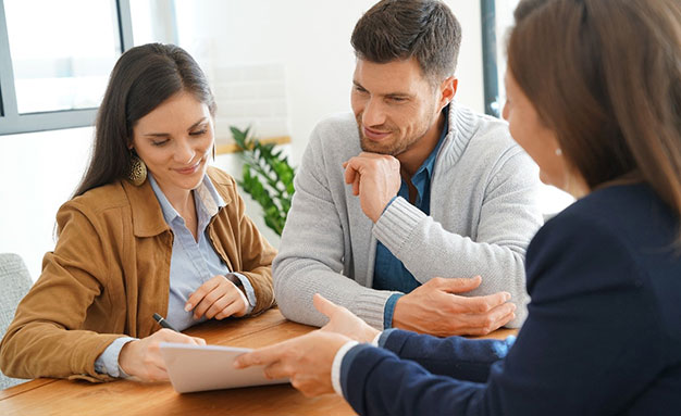 Financial adviser signing paperwork with clients