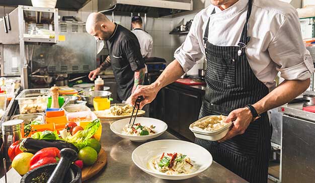 Professional chefs cooking food in kitchen restaurant