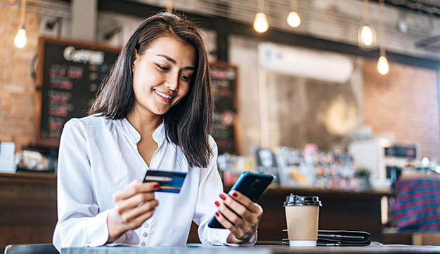 Young female expat using phone to bank