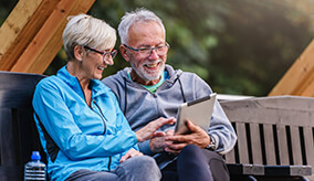 Old couple sat on a bench calculating their retirement funds