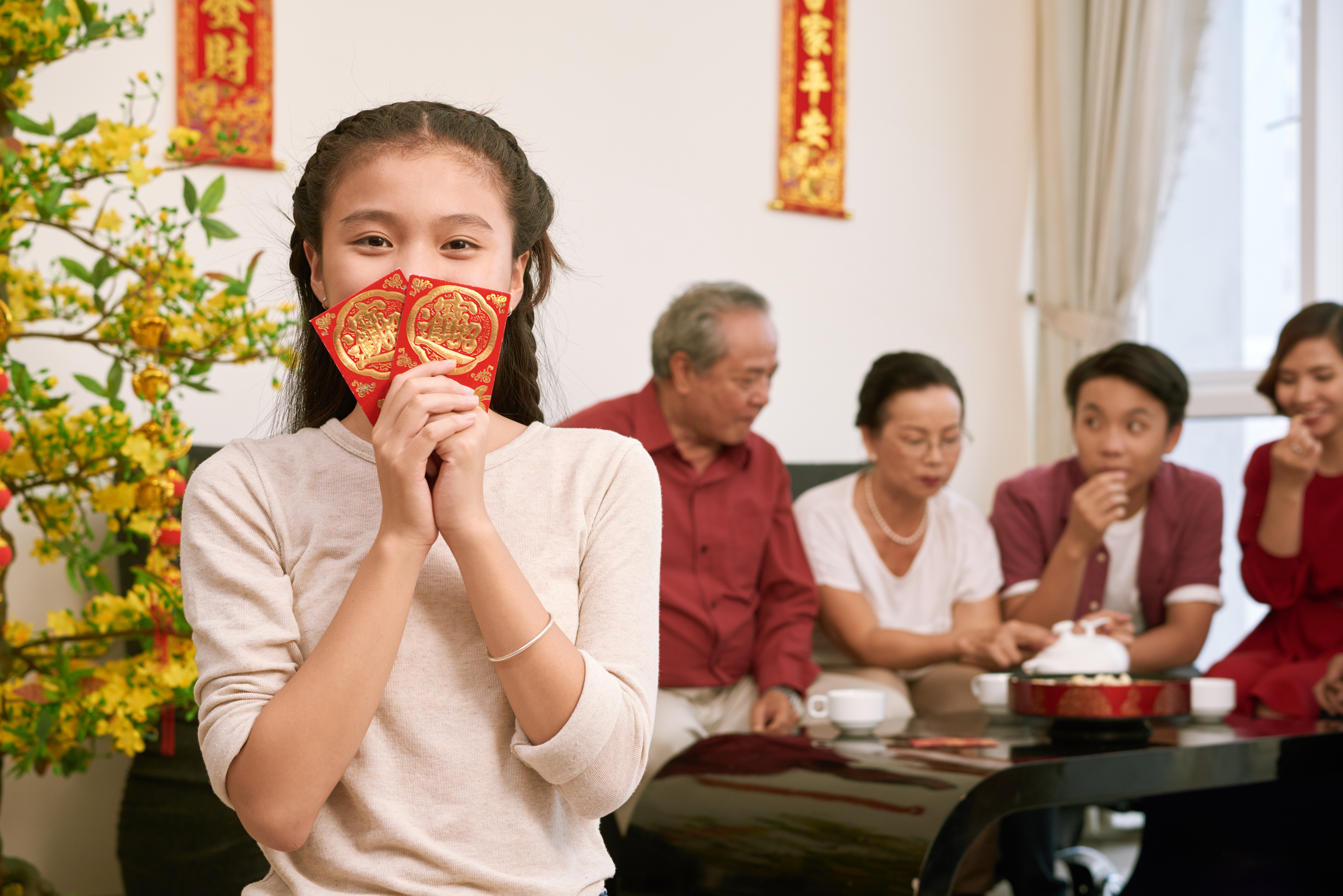 a girl holding a traditional Chinese red envelope.