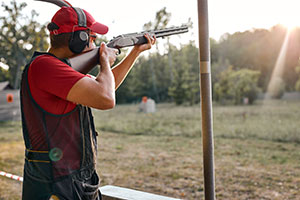 Man taking a shot using a rifle dressed in red