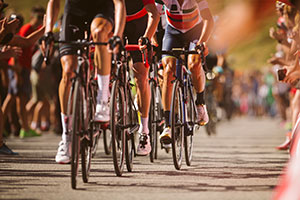 Cyclists participating on a road race, large crowds gathering either side