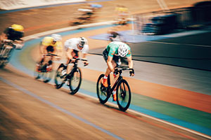Cyclists in the velodrome, cycling so fast they are a blur