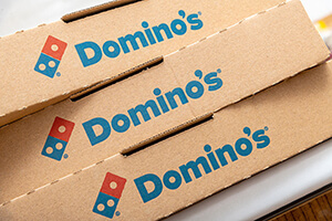 Stack of three pizza boxes with Domino's logo on the side