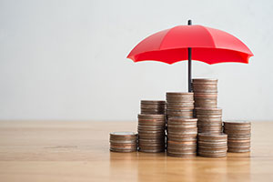 A pile of coins beneath and umbrella