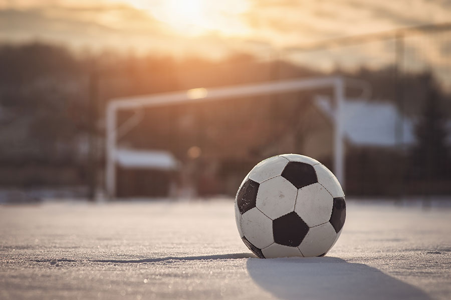 Football sat on a snow covered pitch