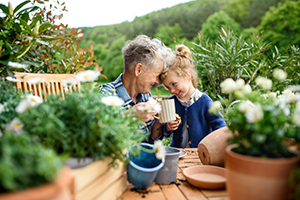 Grandparent and grandchild close together smiling in a garden