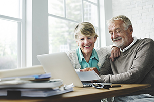 Retired couple sat on laptop together