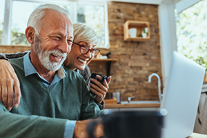 Retired couple looking at laptop smiling