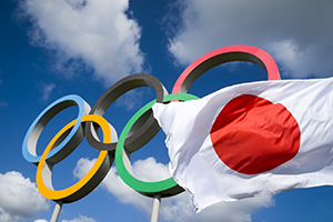 Olympic rings behind a Japanese flag
