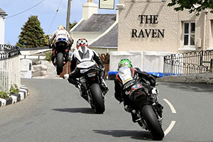 Motorbikes speeding over Ballaugh Bridge with The Raven in the background