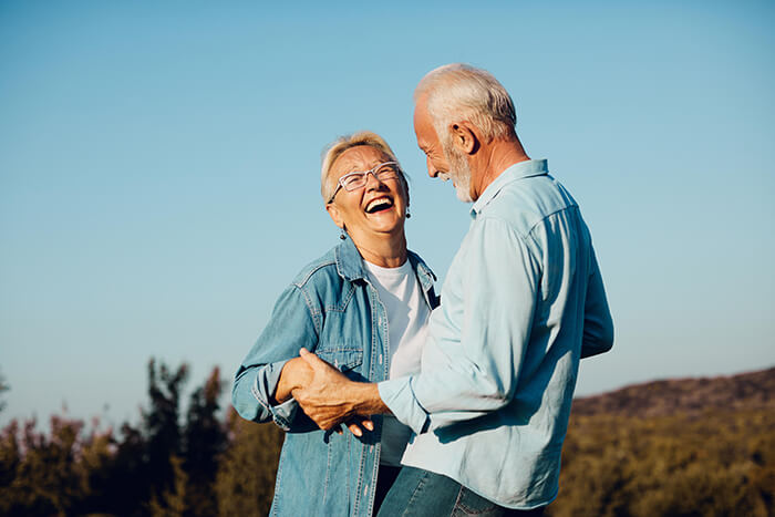 a couple laughing at each other wearing blue.