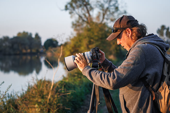 a person looking through a camera on a tri-pod